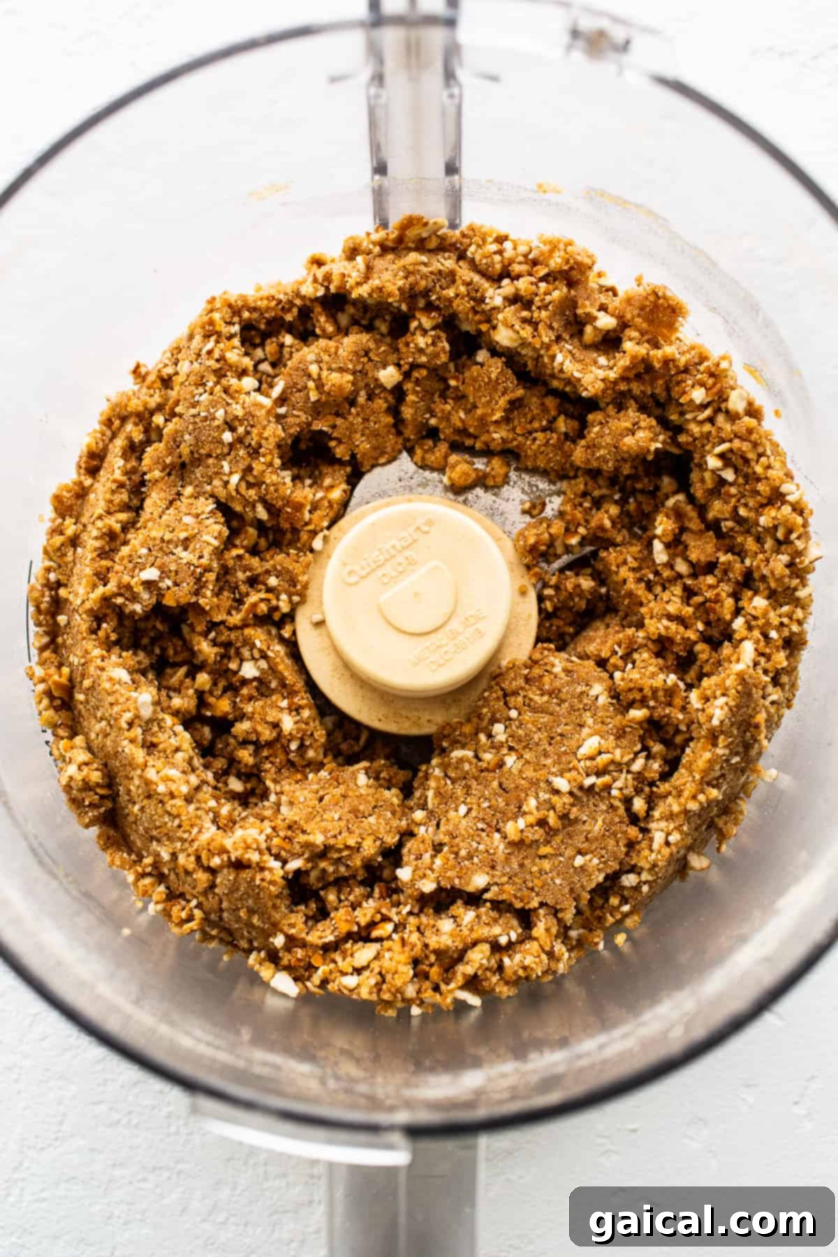 Food processor with pretzel crumbs, illustrating the first step of making the salty pretzel crust for Margarita Pie Bars.