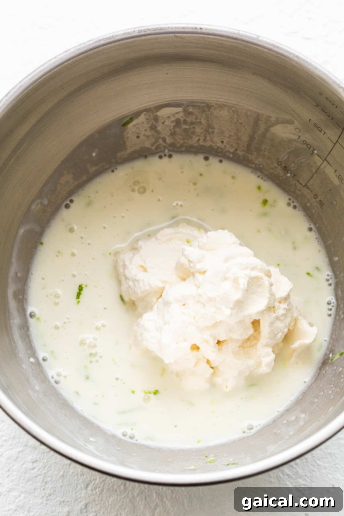 Bowl filled with the creamy, zesty margarita pie filling, ready to be spread over the crust.