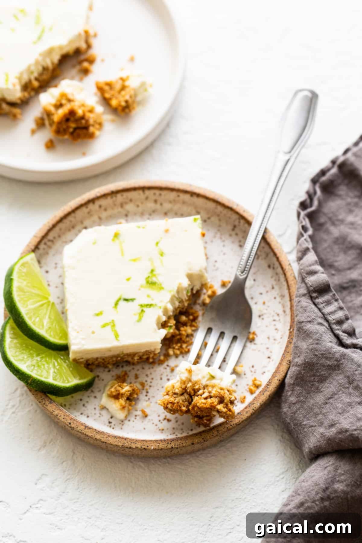 A single Margarita Pie Bar on a white plate with a fork, garnished with lime zest, ready to be enjoyed.