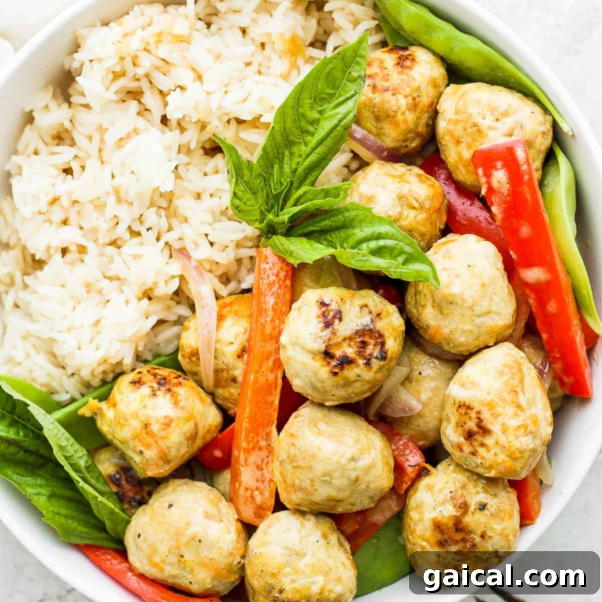 Chicken meatballs, vegetables, and rice in a bowl.
