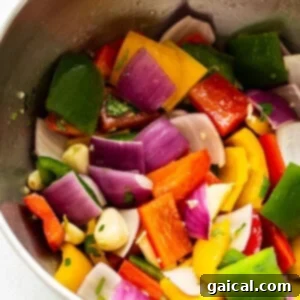 Kaleidoscope Chicken Skewers 12 A bowl filled with colorful, chopped bell peppers and purple onions.