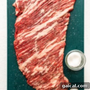 Sizzling Steak Fajitas 6 A piece of flank steak being tenderized on a cutting board.