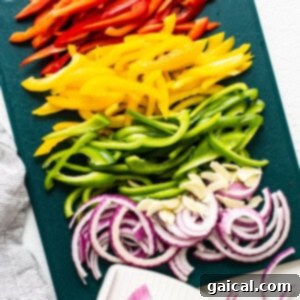 Sizzling Steak Fajitas 7 Sliced bell peppers and onions on a cutting board.