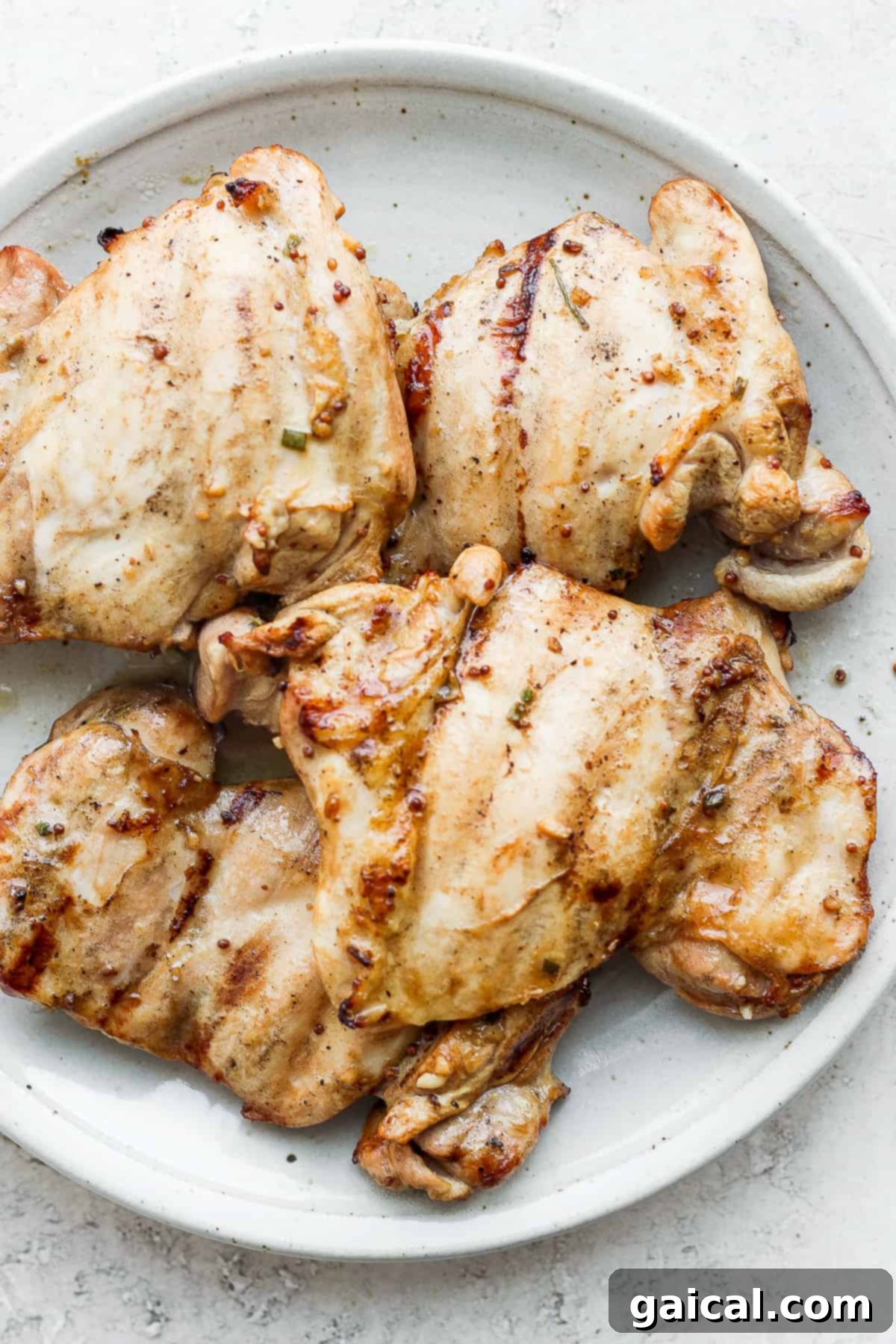 Chicken thighs on plate, marinated and ready to cook.