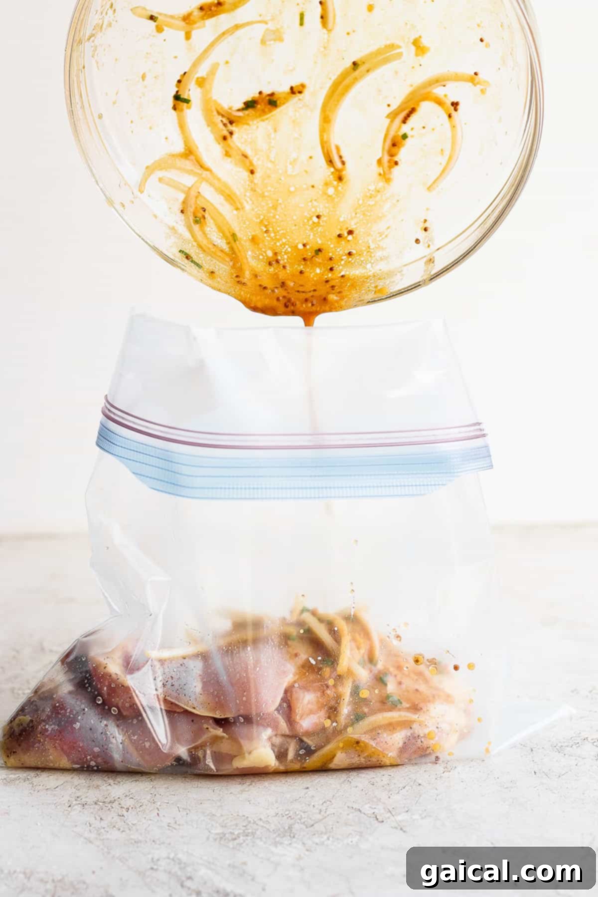 Honey mustard chicken thighs marinade being poured into a gallon-size bag with chicken.