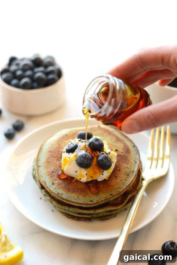 Delicious stack of Blender Lemon Blueberry Pancakes with fresh blueberries and lemon slices