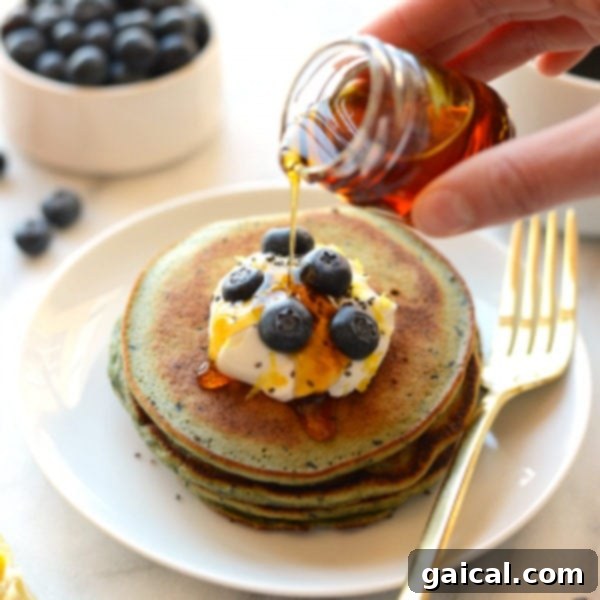 Stack of Blender Lemon Blueberry Pancakes with fresh fruit and syrup