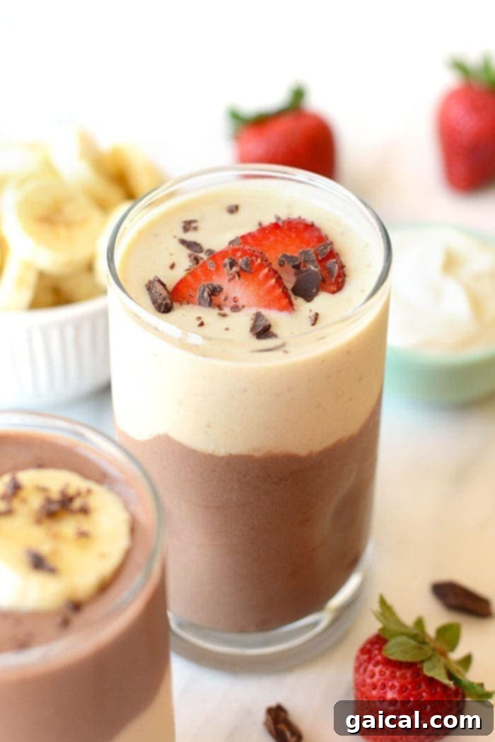 Layered Chocolate Banana Protein Smoothie Delicious Layered Chocolate Banana Protein Smoothie, topped with fresh strawberries, ready to be enjoyed.