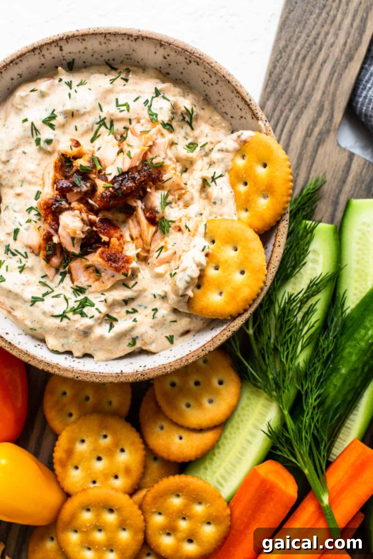 Easy Smoked Salmon Dip: Creamy and Savory Delight Creamy smoked salmon dip artfully arranged in a rustic bowl, garnished with fresh dill and a sprinkle of black pepper, ready to be served with a side of crispy crackers.