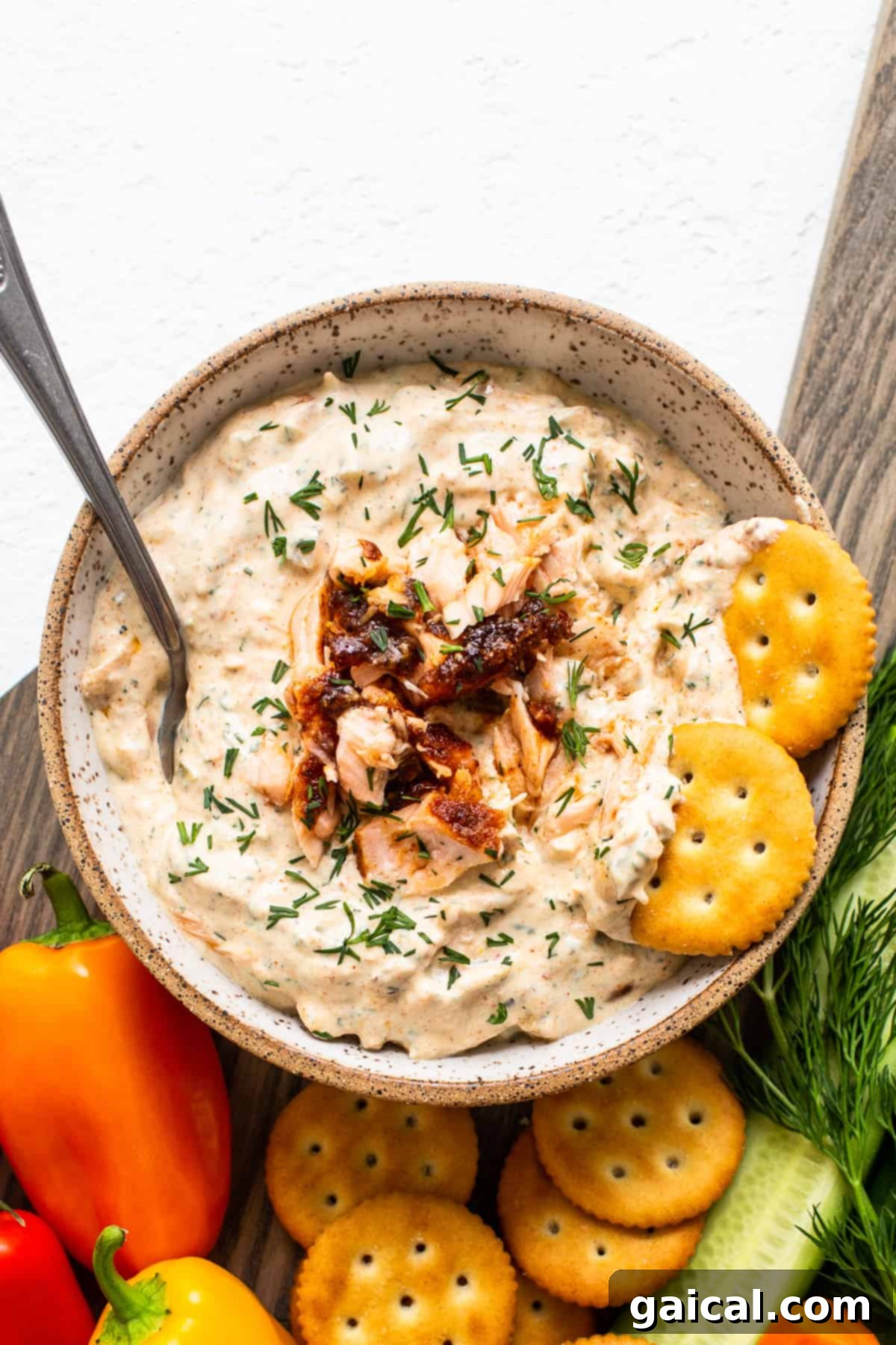 The Rich, Creamy Texture of Our Smoked Salmon Dip A close-up of a rustic white bowl overflowing with the creamy smoked salmon dip, showcasing its rich texture and delicate garnish of fresh dill, ready to be served or stored.
