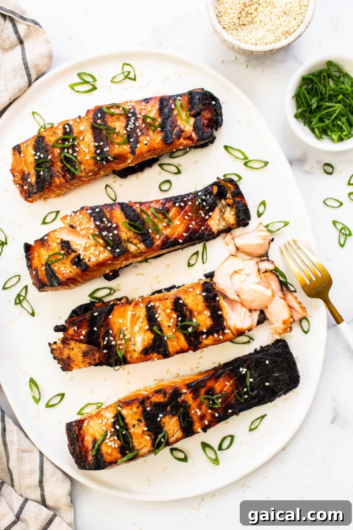This yummy honey glazed salmon comes our caramelized and flakey. It's made with honey, soy sauce, and fresh ginger! Perfectly cooked, caramelized honey glazed salmon fillet resting on a white plate, garnished with fresh herbs and ready to be enjoyed.