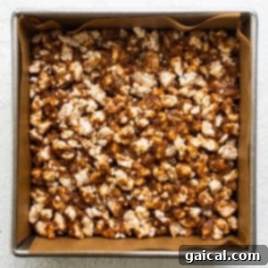 Rice Cake Dream Bars 9 Caramel popcorn in a pan on a white surface, showing the pressed base.