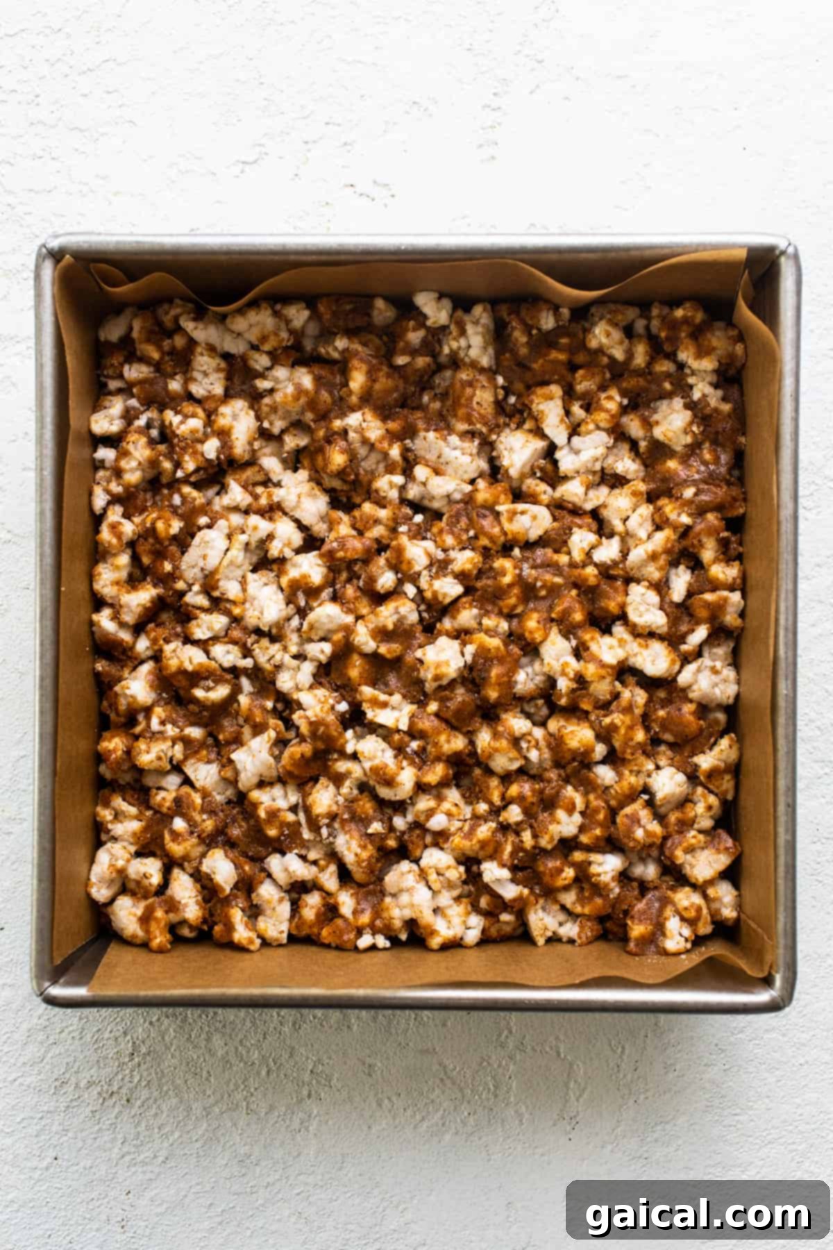 Rice Cake Dream Bars 4 A close-up of a pan with a sticky, golden mixture, representing the base of the magic bars before pressing.