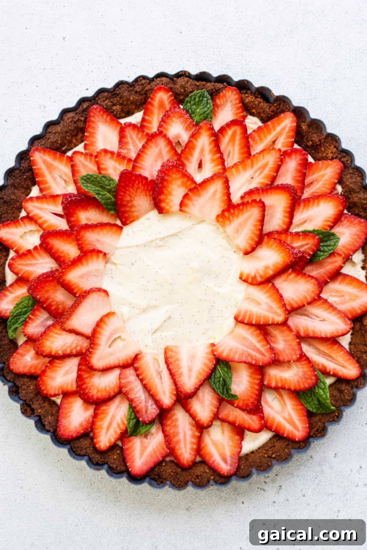 Pistachio-Crusted Strawberry Delight 5 A beautifully decorated strawberry tart, seen from a high angle, ready to be sliced.