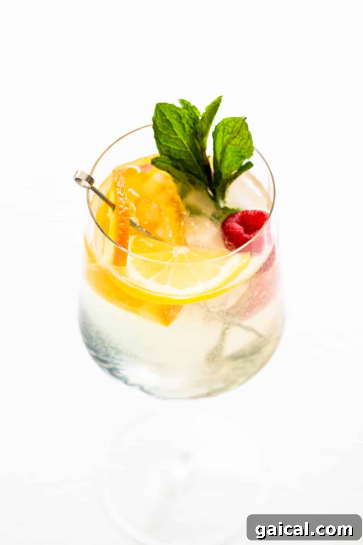Crisp White Wine Refresher 6 A beautifully prepared white wine spritzer in a glass, garnished with fresh mint, highlighting its appeal as an easy-to-make pitcher drink for entertaining.