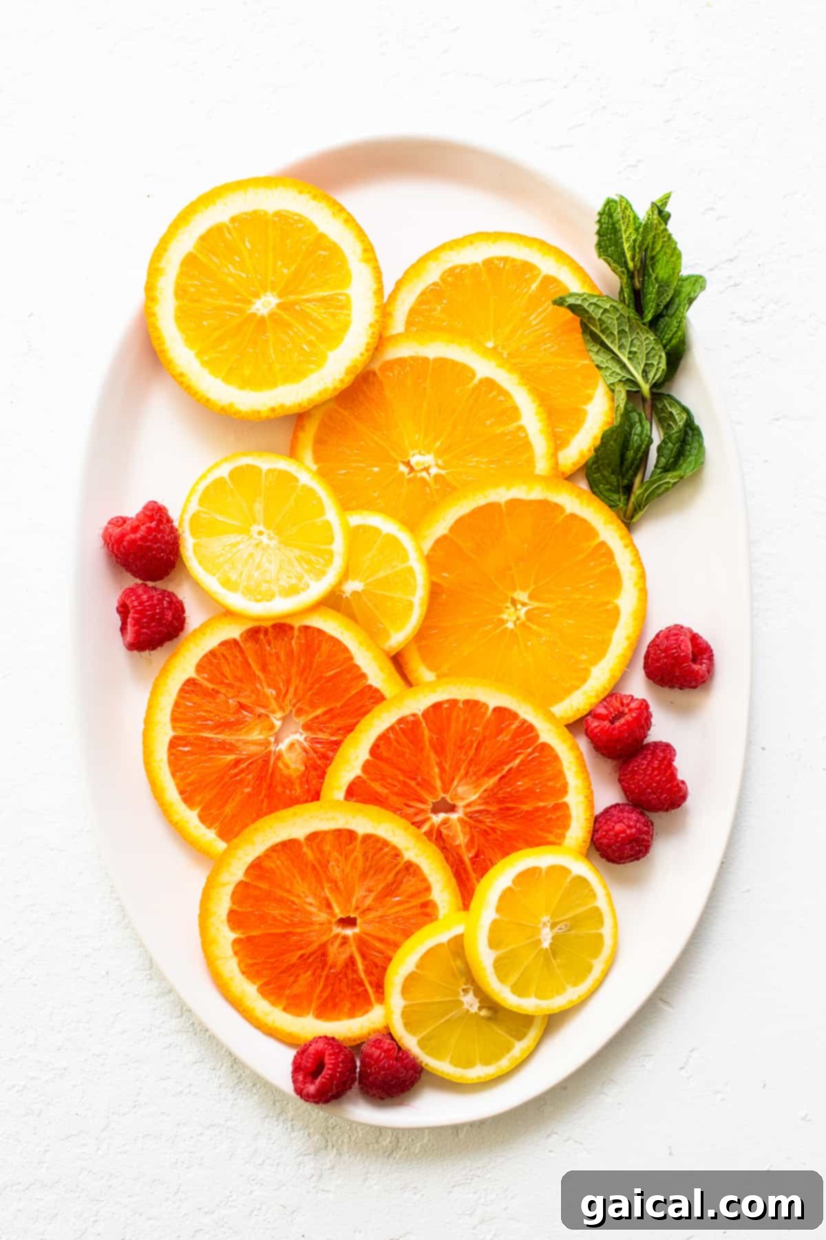 Crisp White Wine Refresher 3 An assortment of vibrant fresh fruits and aromatic herbs laid out on a clean white plate, ready to elevate your white wine spritzer.