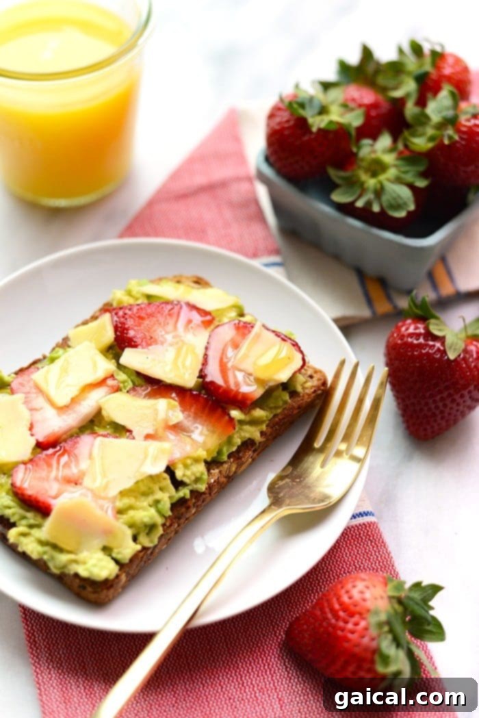 Sweet & Savory Berry Avo Cheddar Toast 2 Gourmet breakfast toast topped with fresh strawberries, creamy avocado, and sharp white cheddar cheese.