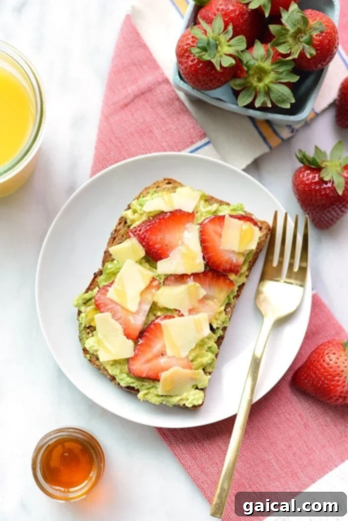 Sweet & Savory Berry Avo Cheddar Toast 3 Close-up of a delicious piece of toast with strawberries, avocado spread, and white cheddar.