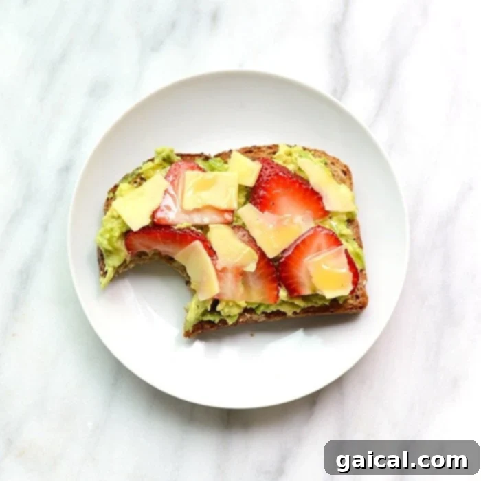 Sweet & Savory Berry Avo Cheddar Toast 5 A beautifully prepared Strawberry, Avocado, and White Cheddar Toast on a plate.