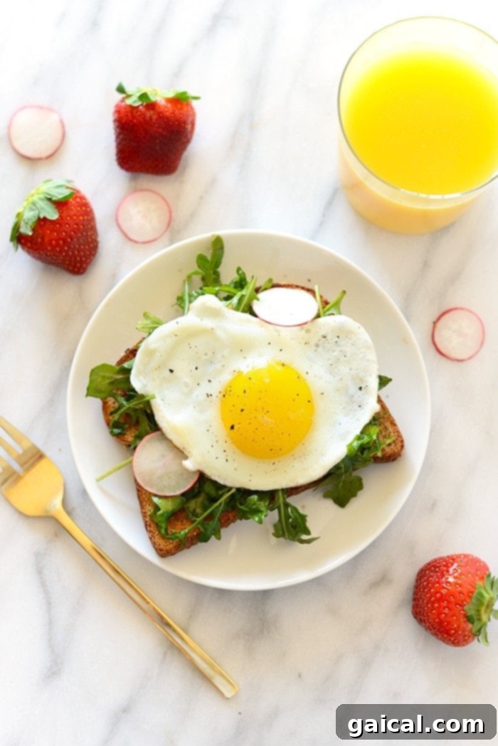 Egg and Arugula Toast for Toast Tuesday 6 Overhead shot of Egg and Arugula Toast on a rustic wooden board, garnished with herbs