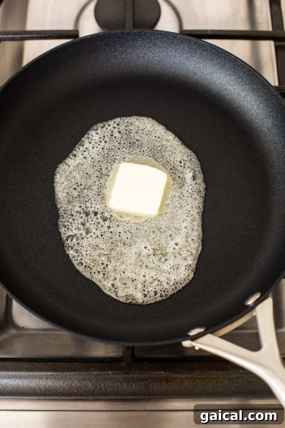 Butter melting in a non-stick skillet over medium-low heat.