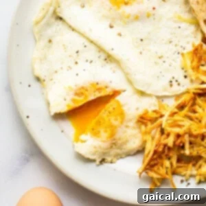 A plate with a fried egg, potatoes and toast, showcasing over medium eggs.