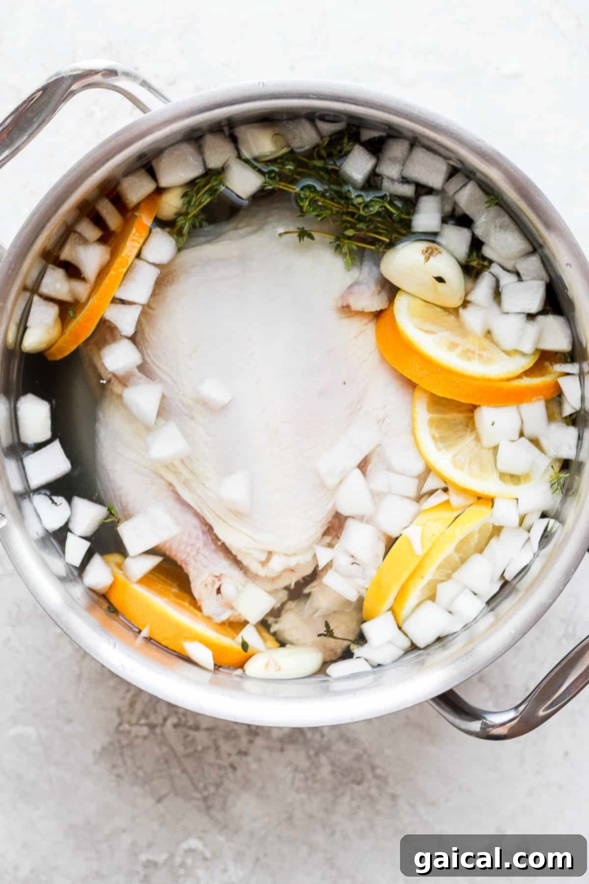 This simple, classic whole chicken brine gives you the juiciest, most delicious whole chicken you’ve ever tasted. A whole chicken submerged in brine in a large pot, ready for chilling.