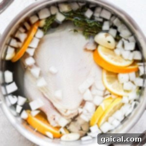 A simple yet effective chicken brine in a pot with various fresh ingredients.
