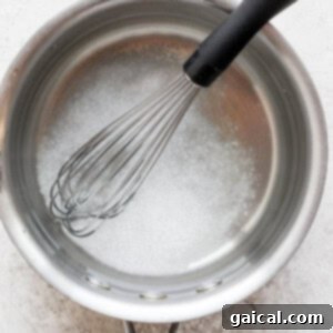 Water and salt in a pot, being whisked to dissolve the salt.