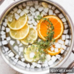 Brine ingredients including garlic, onion, citrus, and thyme in a pot.