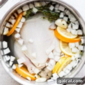 Whole chicken soaking in brine in a pot.