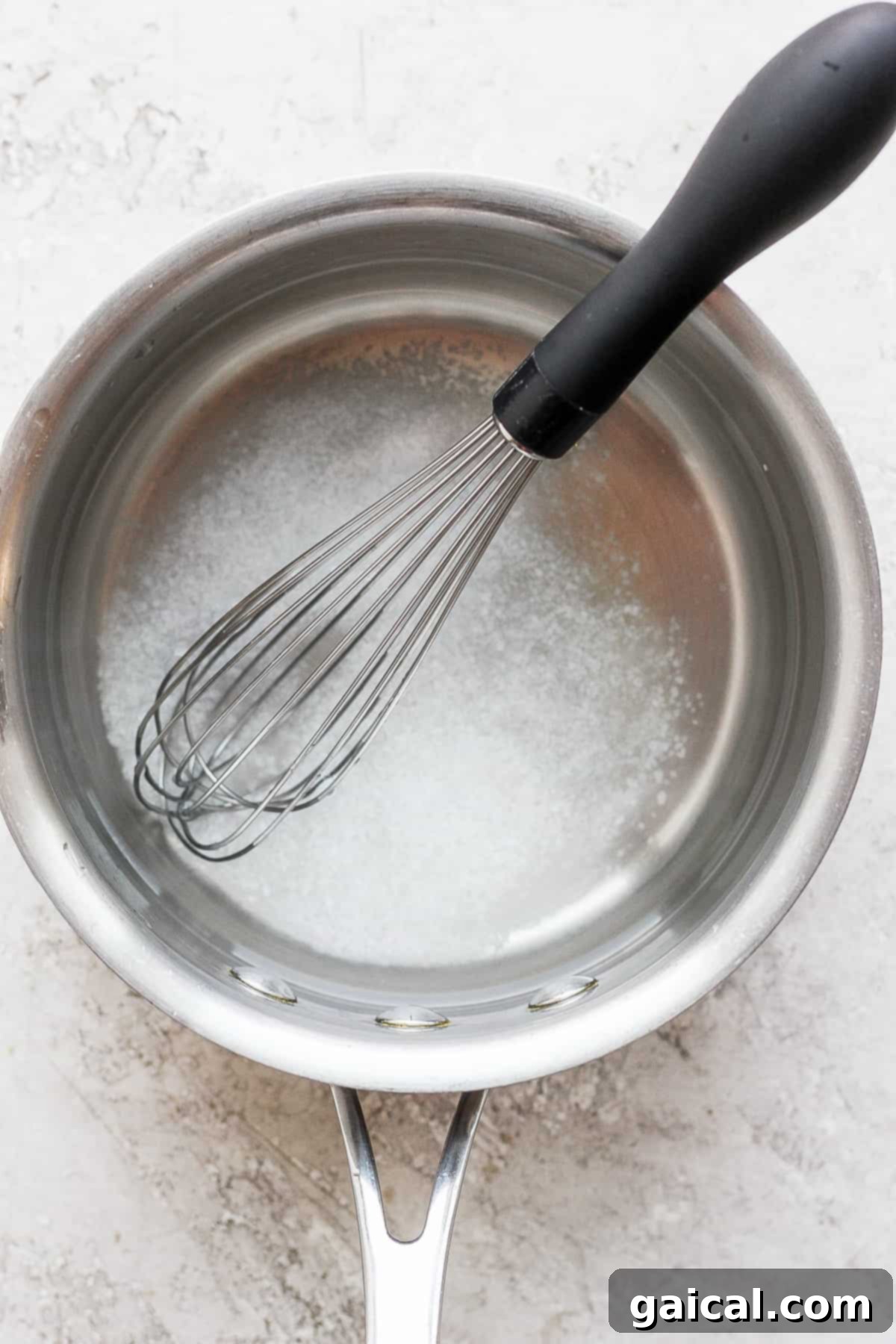 This simple, classic whole chicken brine gives you the juiciest, most delicious whole chicken you’ve ever tasted. Kosher salt dissolving in warm water with a whisk, an essential step for the chicken brine.