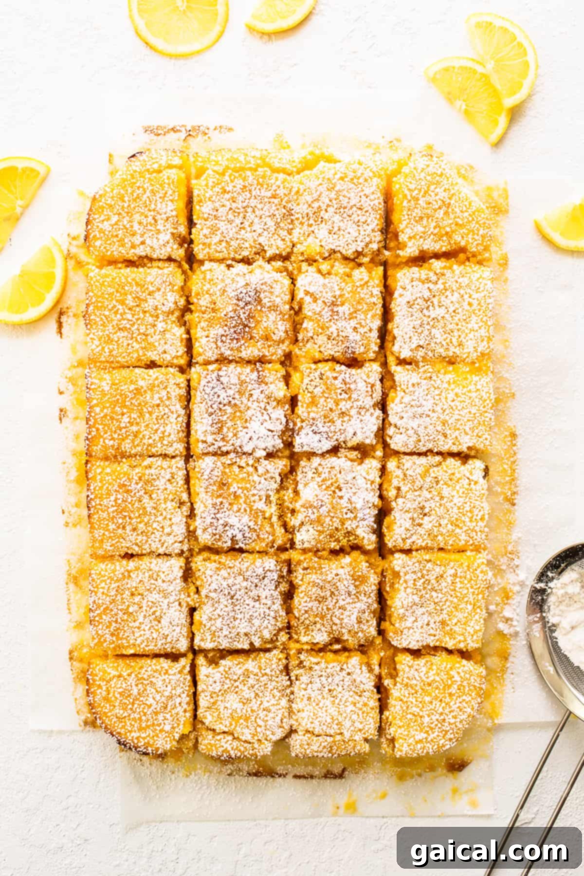 Zesty Lemon Bars 5 Finished lemon bars on a cutting board, garnished with fresh lemon wedges.