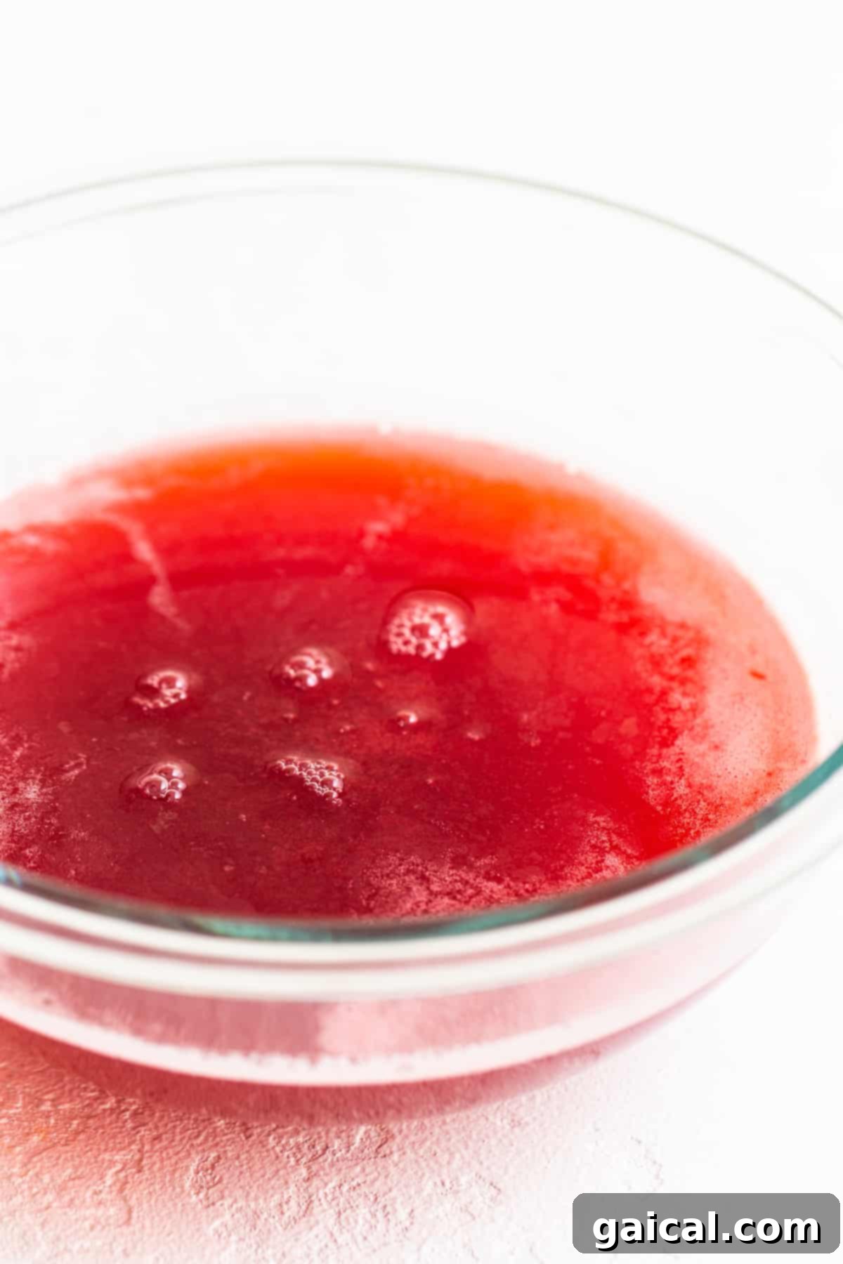 Chilled Homemade Raspberry Juice Base A beautiful bowl filled with freshly strained, bright red honey-raspberry juice, shimmering and ready to be chilled and used as the foundation for the summer punch.