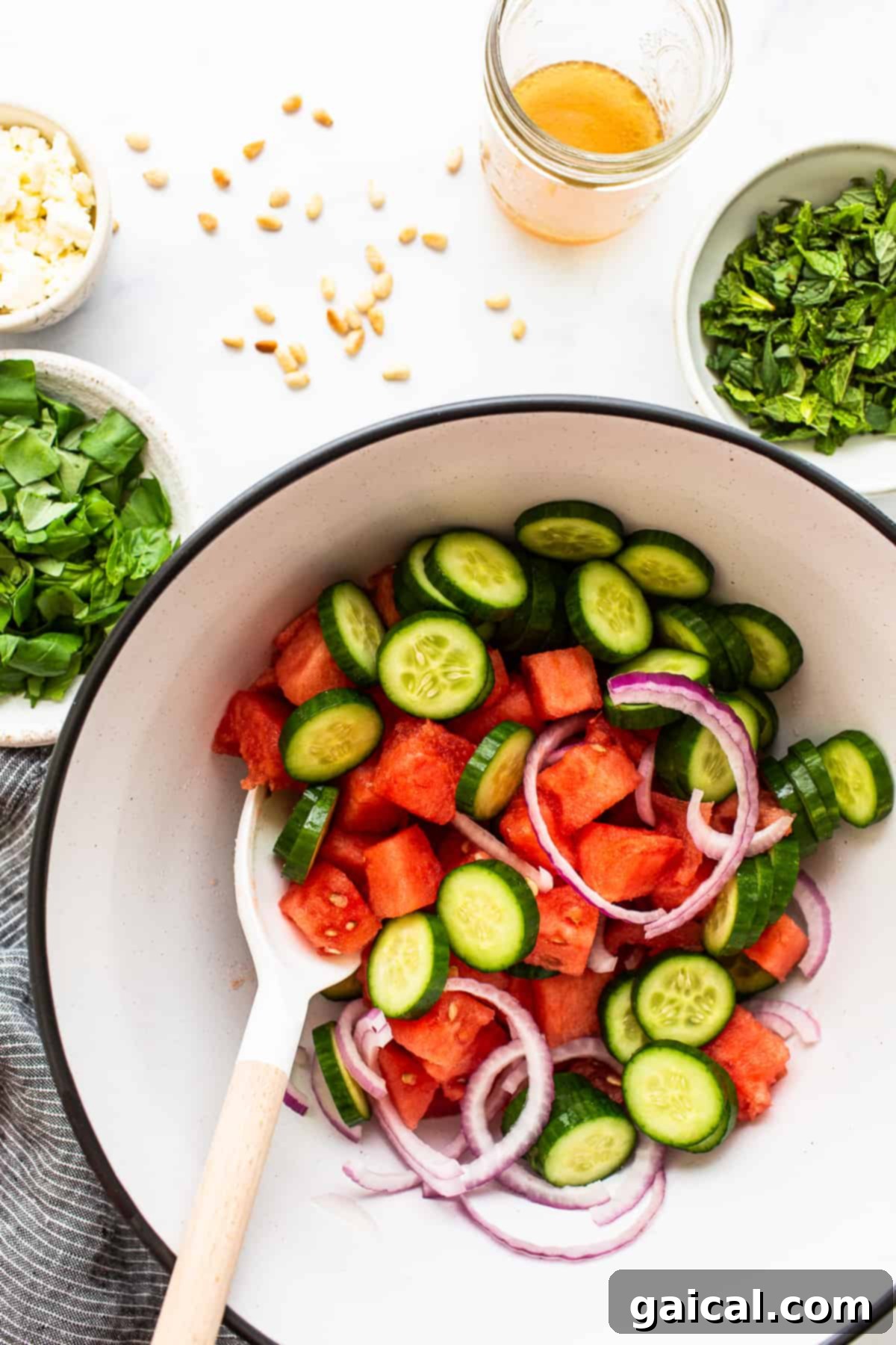 Large bowl of prepared watermelon feta salad, garnished with fresh mint.