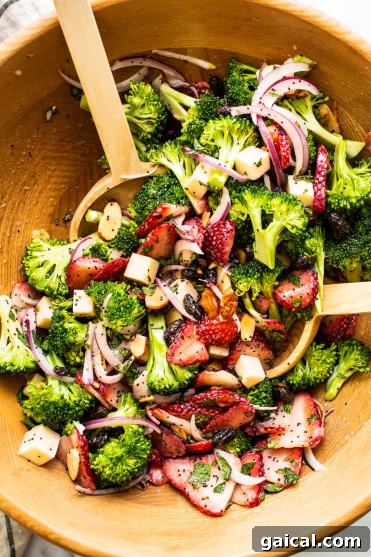 Delicious Strawberry Broccoli Salad with Poppy Seed Dressing Strawberry broccoli salad in a wooden bowl, showcasing its fresh and vibrant ingredients.