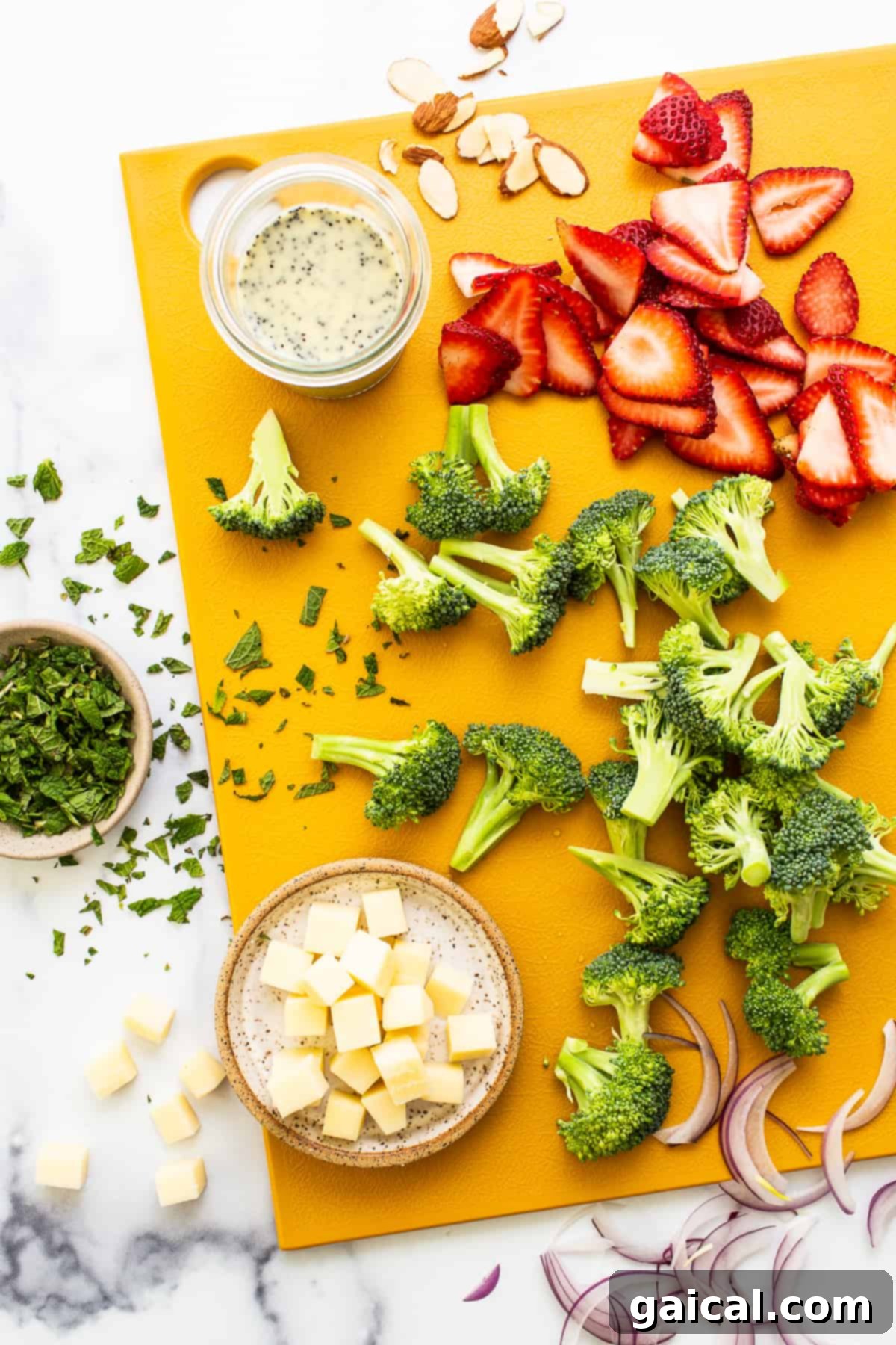Fresh Ingredients for Strawberry Broccoli Salad Ingredients for strawberry broccoli salad laid out on a cutting board, ready for preparation.