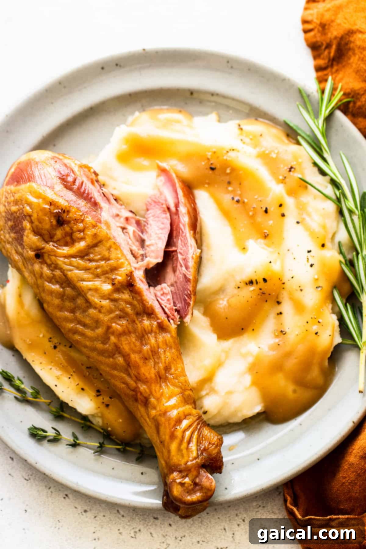 Smoked turkey legs elegantly served alongside creamy mashed potatoes on a plate.