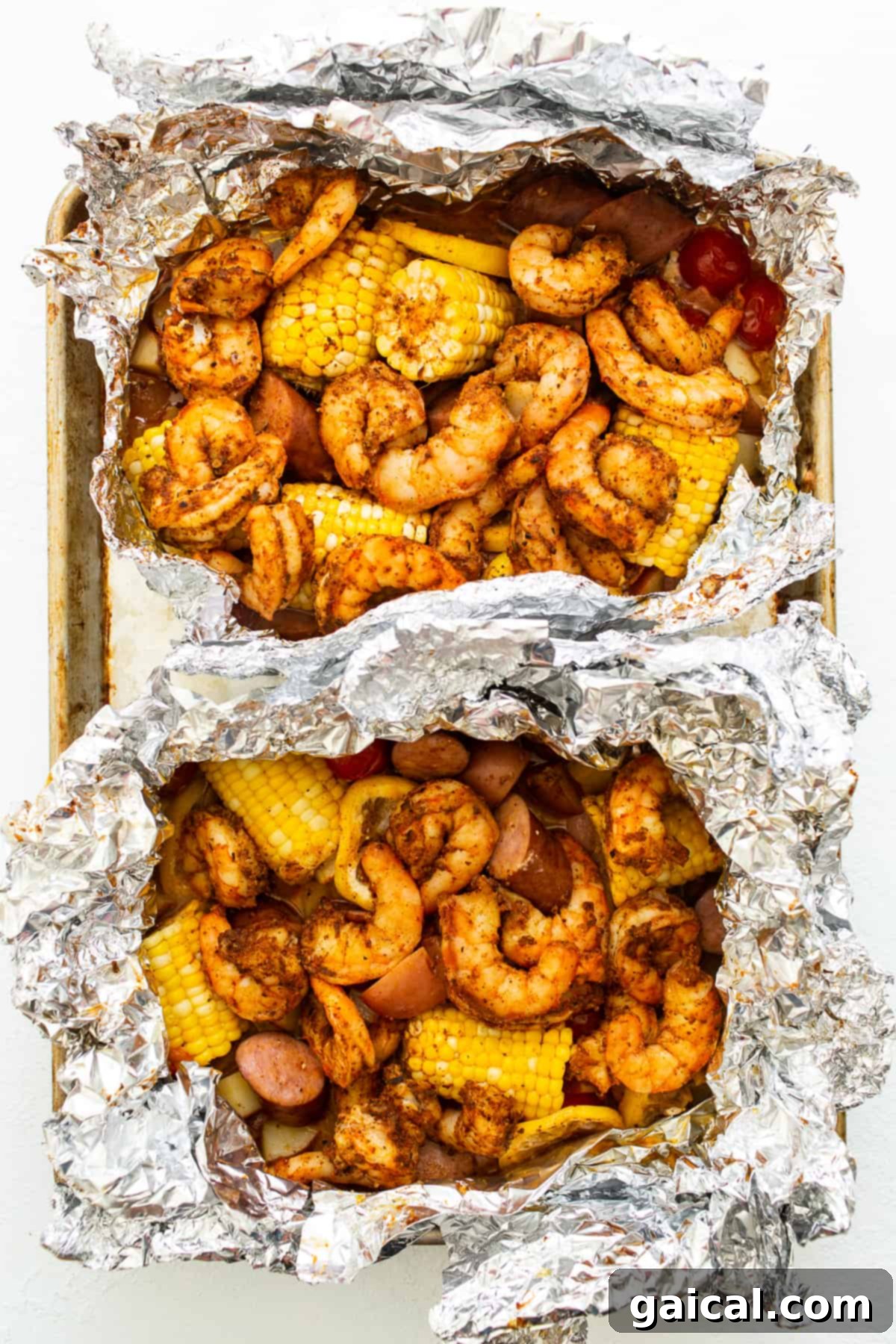 Zesty Shrimp Grill Parcels 6 All ingredients for grilled shrimp foil packets assembled in two large foil packs, perfectly arranged and ready for cooking.