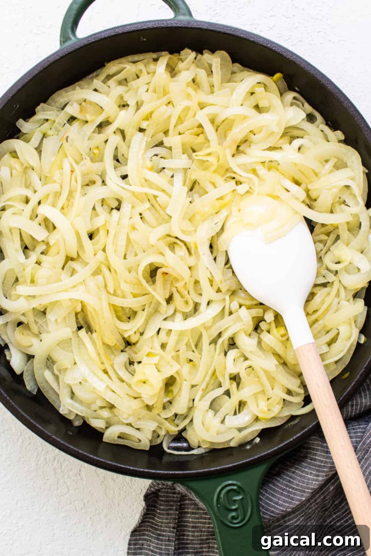 Effortless Caramelized Onions 5 A generous quantity of perfectly caramelized onions simmering gently in a large cast iron skillet, showcasing their rich color and texture.