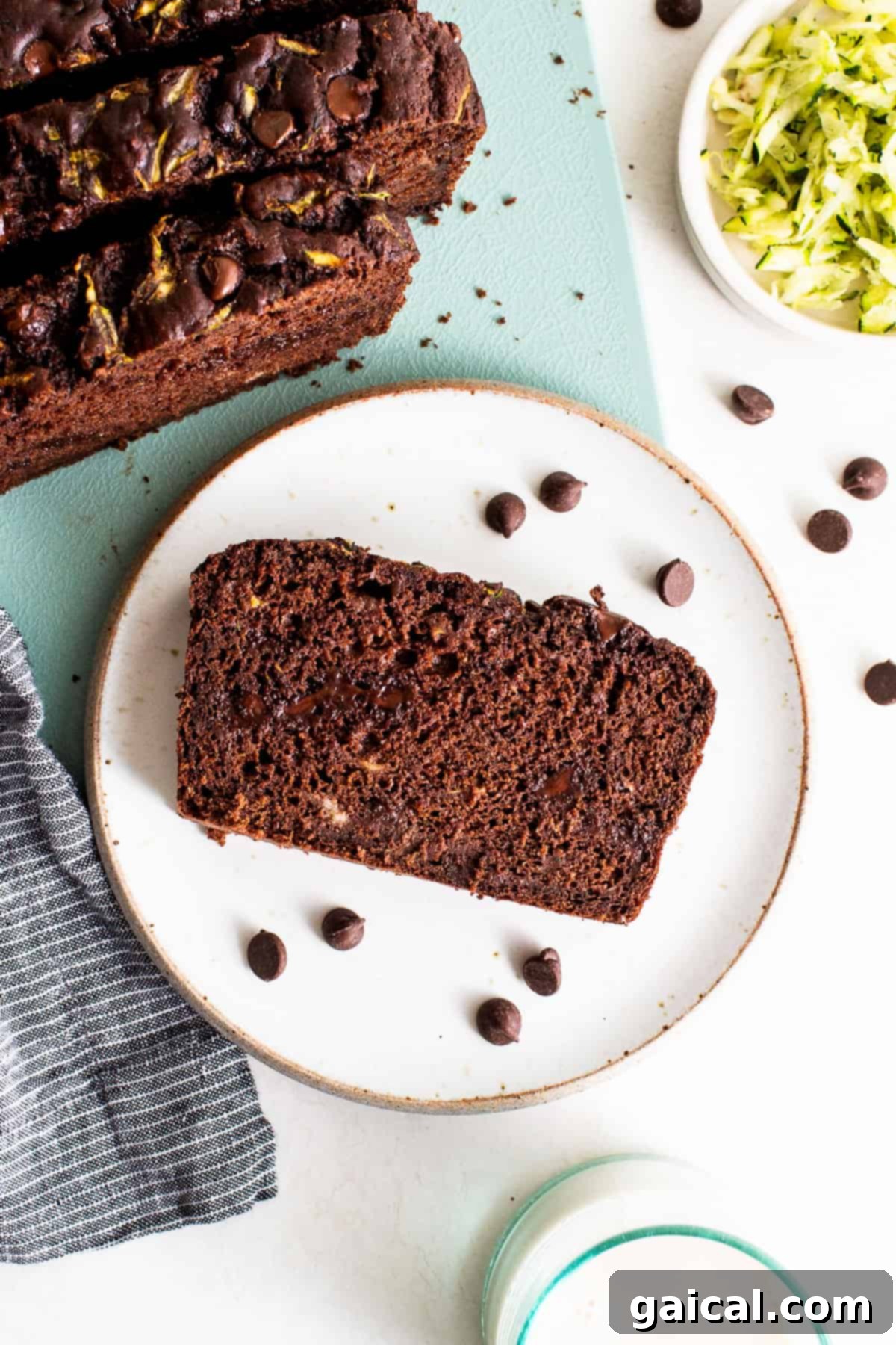 Slice of chocolate zucchini bread on a plate, showing its moist texture and chocolate chips.