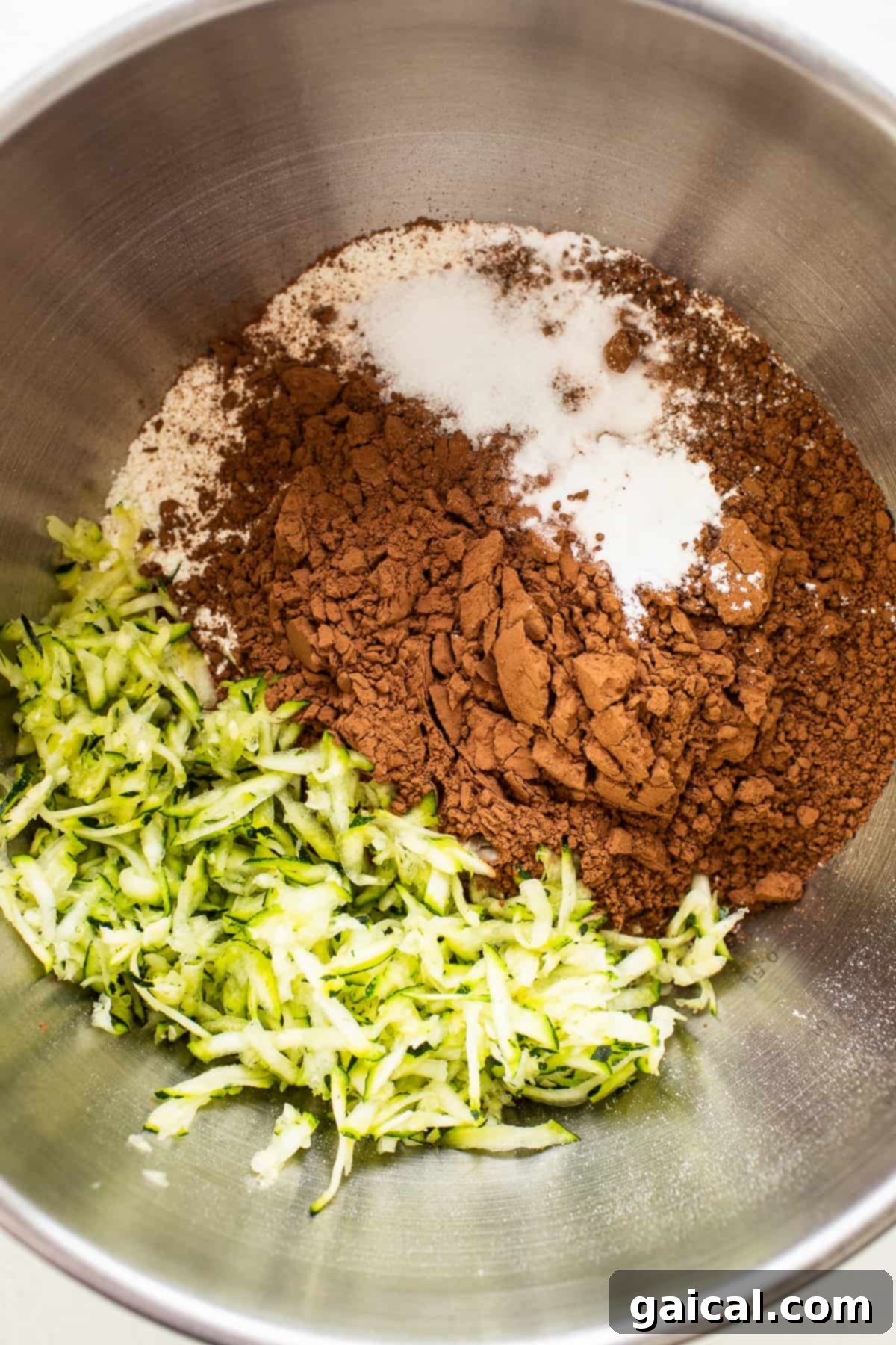 Dry ingredients for chocolate zucchini bread meticulously arranged in a bowl, ready for mixing.