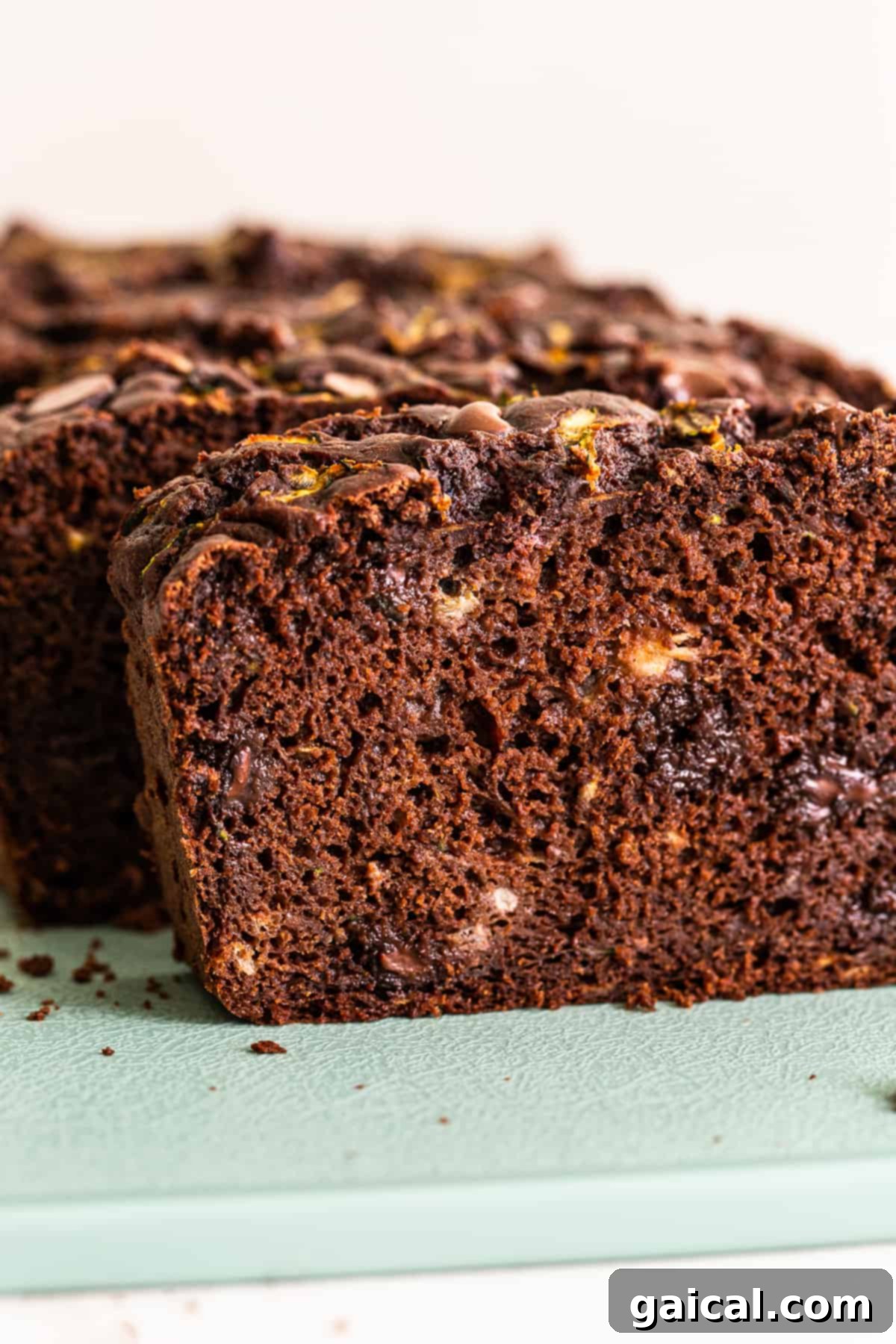 A perfectly sliced piece of chocolate zucchini bread, showcasing its fluffy texture and molten chocolate.