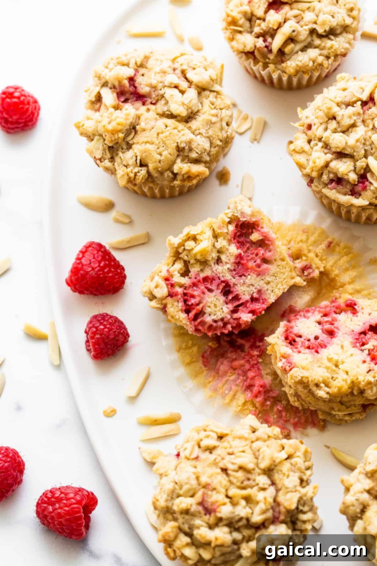 Bursting Raspberry Muffins 10 A freshly baked raspberry muffin cut in half, revealing its moist interior, juicy raspberries, and delicate crumb texture.