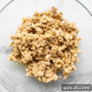 Close-up of streusel topping ingredients being mixed in a bowl, showing the crumbly texture.