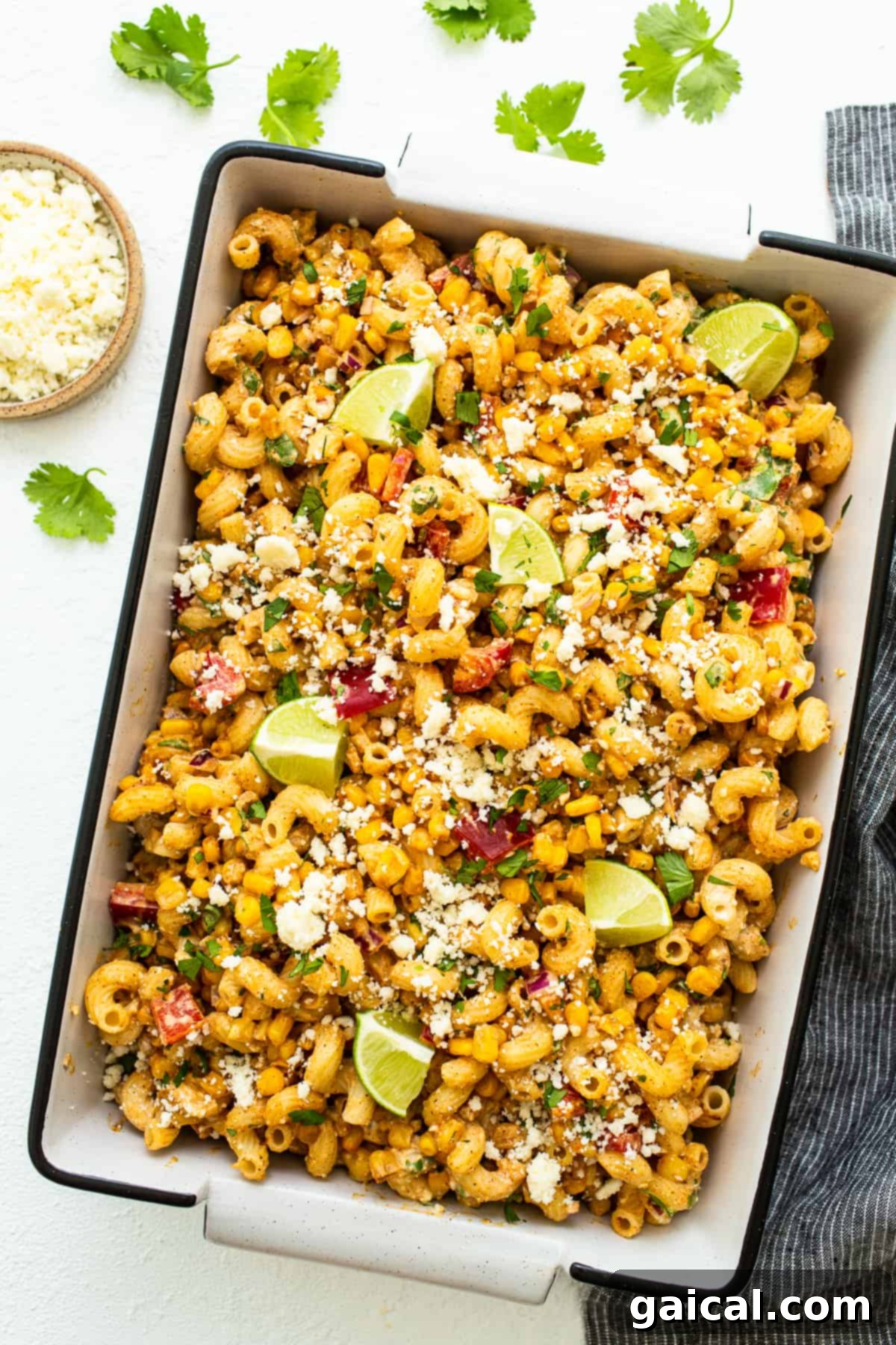 A large bowl of vibrant Mexican Street Corn Pasta Salad ready to be served, garnished with fresh cilantro and cotija cheese.
