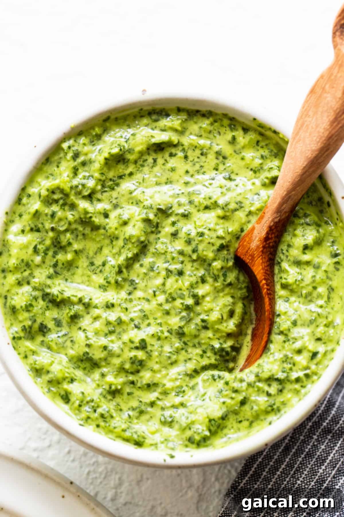 The Ultimate All-Purpose Green Sauce Vibrant green sauce served in a rustic white bowl, garnished with fresh herbs, ready to be enjoyed.