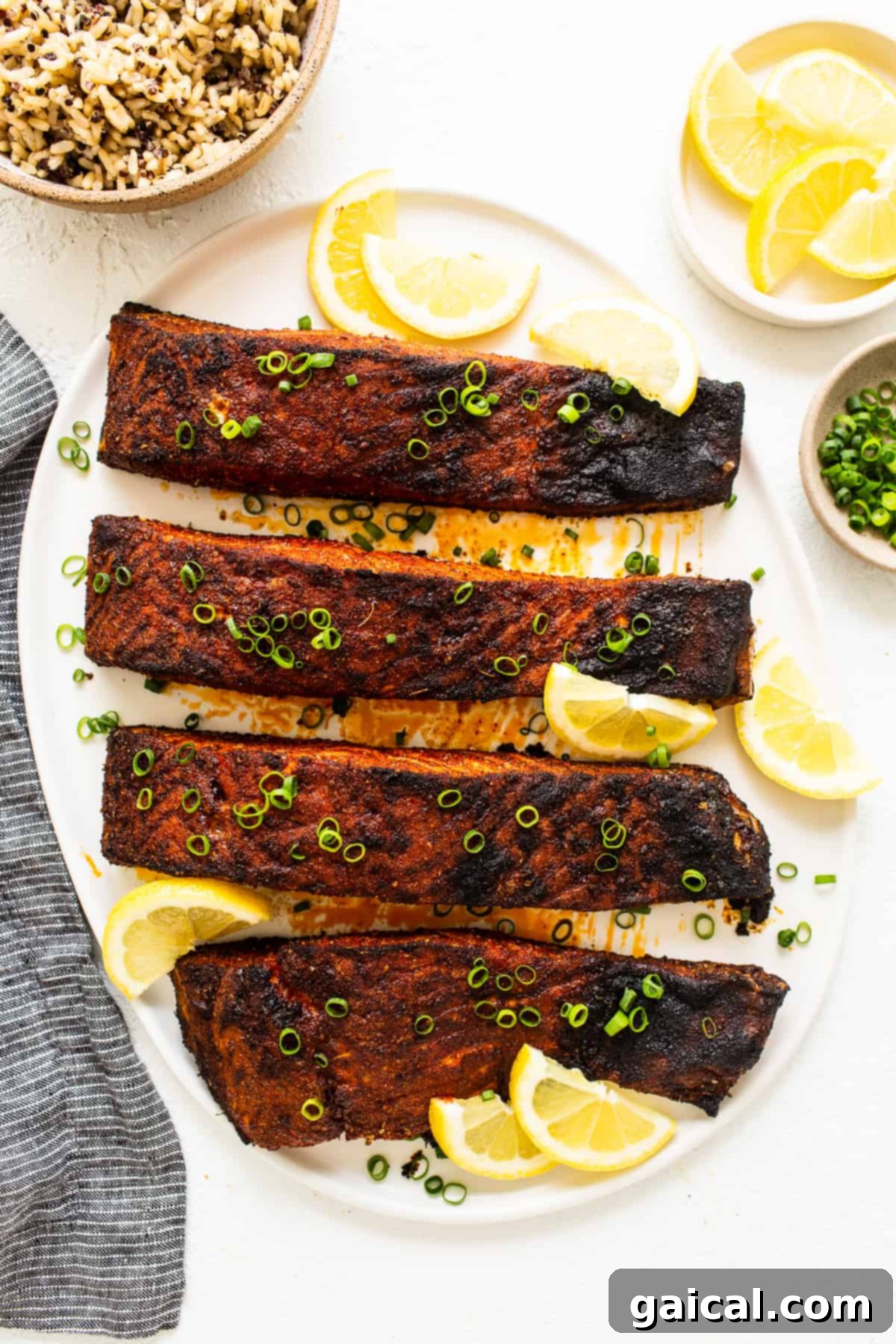 Cajun-Spiced Salmon Fillet 2 Blackened salmon on a plate with fresh lemon slices and a sprig of dill, ready to be served.
