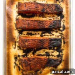 Cajun-Spiced Salmon Fillet 11 Cooked blackened salmon fillets on a baking sheet, showing the distinct dark, crispy crust from broiling.