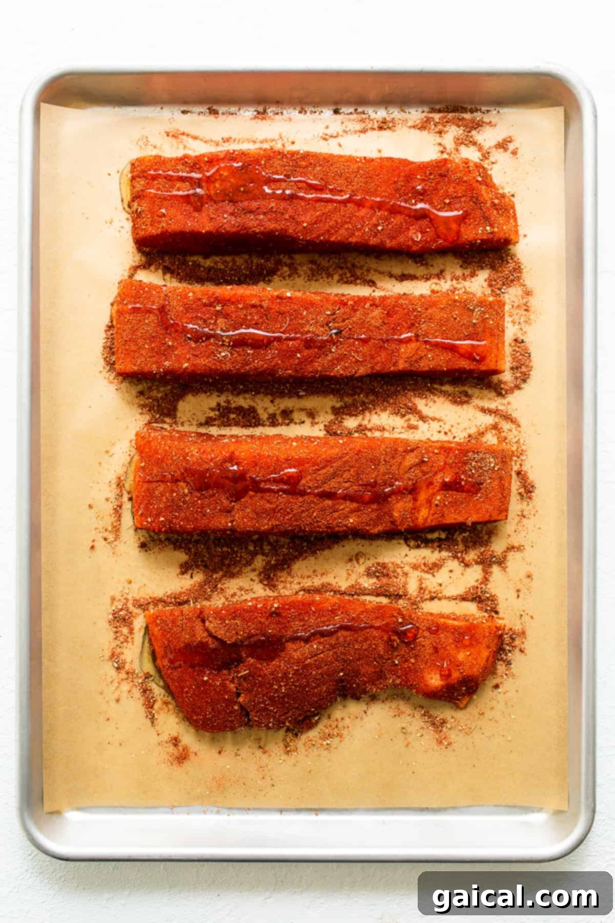 Cajun-Spiced Salmon Fillet 5 Raw salmon fillets evenly coated with a rich cajun seasoning and a light drizzle of oil, ready for broiling.